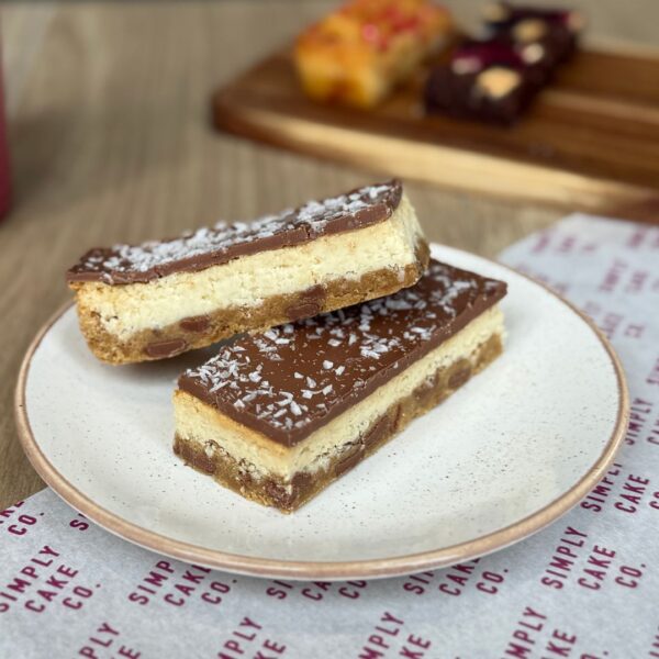 Chocolate coconut traybake slices on a white plate.