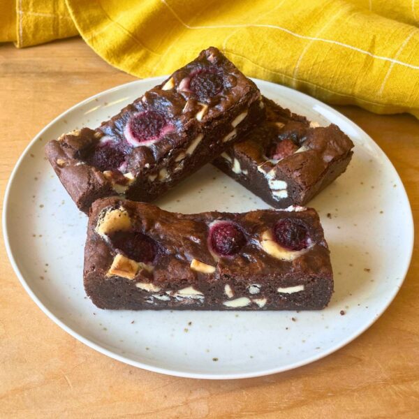 Brownies with raspberries and nuts on a plate.