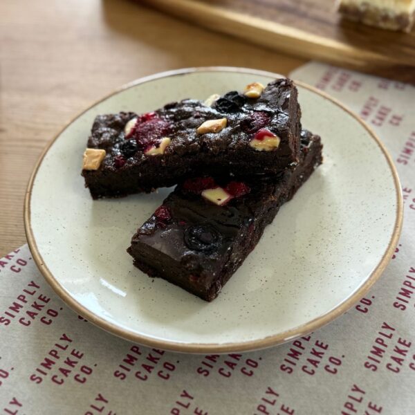 Plate of berry chocolate brownies on table.